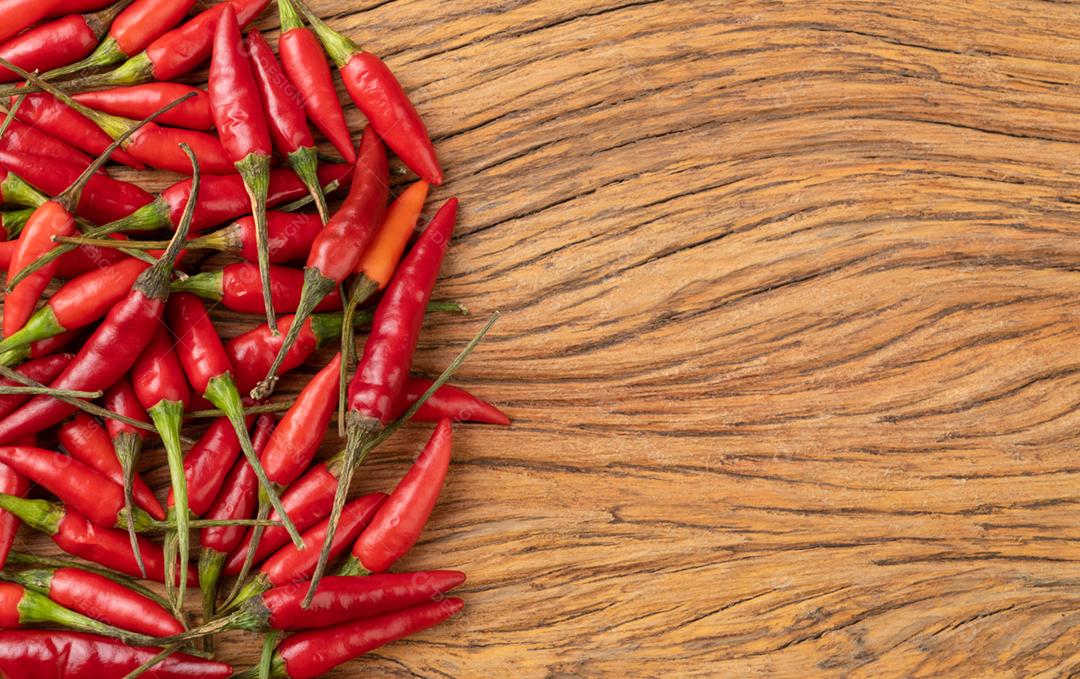 Pimenta malagueta vermelha sobre mesa de madeira