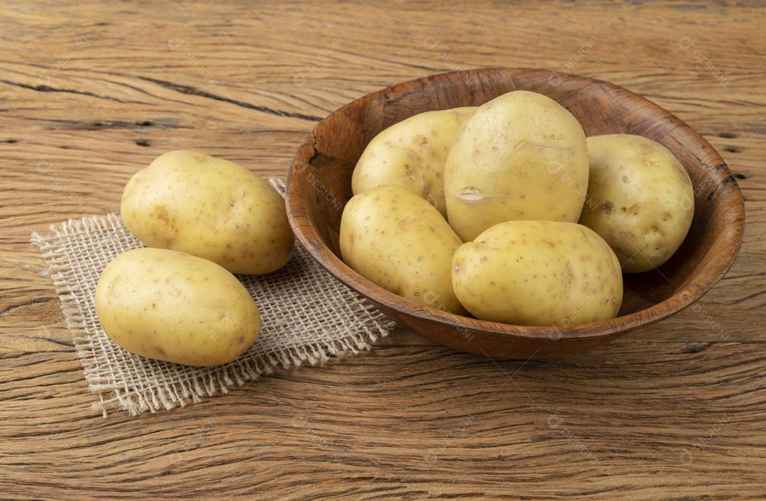 Batatas em uma tigela sobre a mesa de madeira.