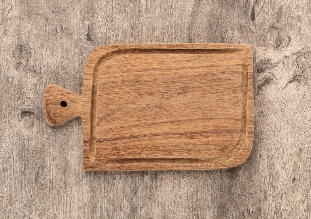Tábua de madeira vazia sobre a mesa de madeira
