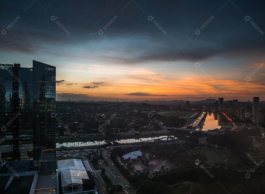 Rio Pinheiros cercado por árvores e escritórios