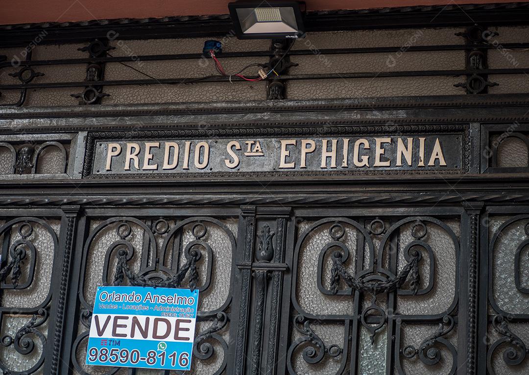 fachada de predio com detalhes em ferro com placa de venda