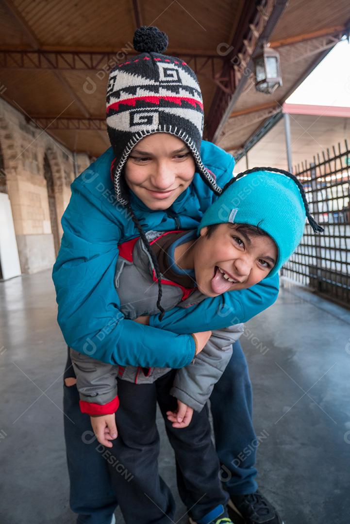 Irmãos posando para a câmera na estação de trem no inverno