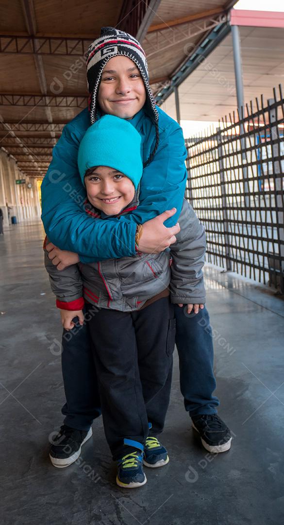 Irmãos posando para a câmera na estação de trem no inverno