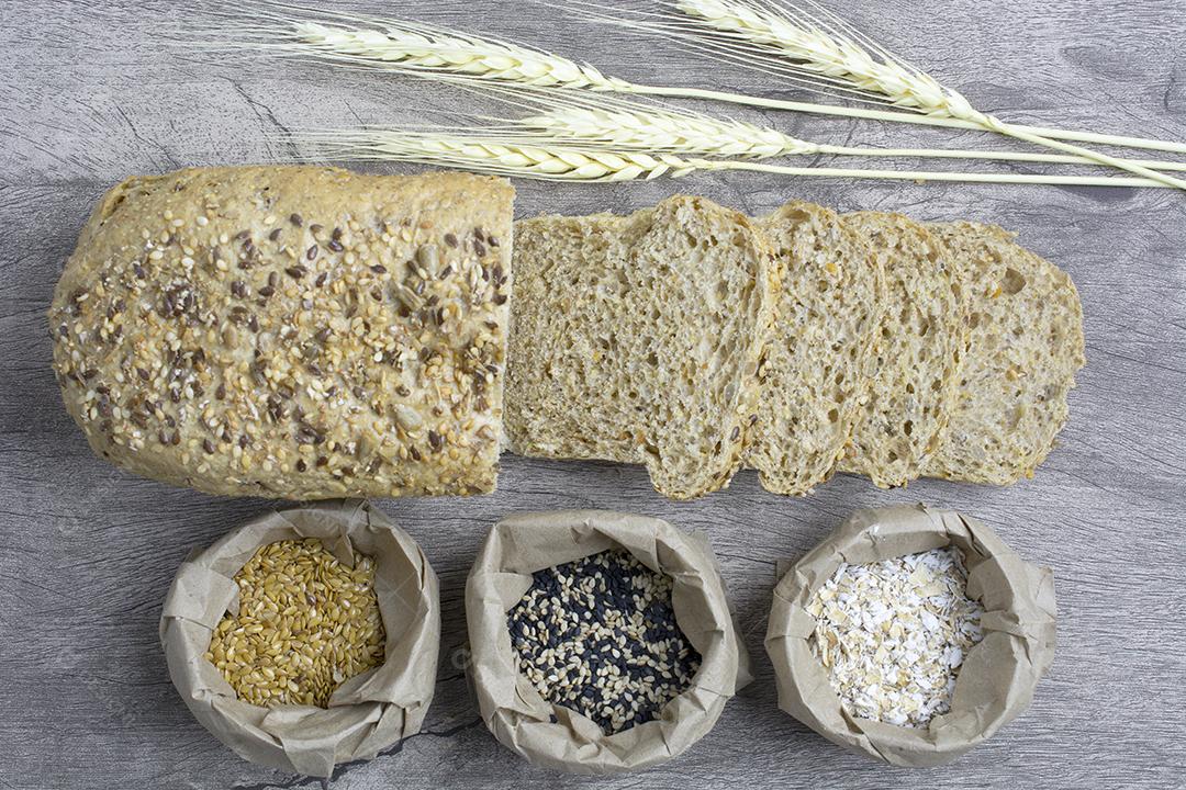 Pão liso fatiado com ingredientes sobre fundo de madeira