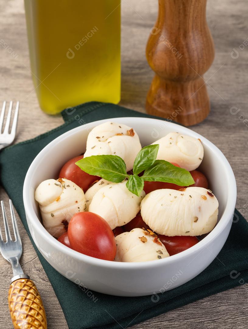 Mussarela Nozinho ou Nó, queijo branco fresco artesanal típico brasileiro com temperos, manjericão e tomate cereja.