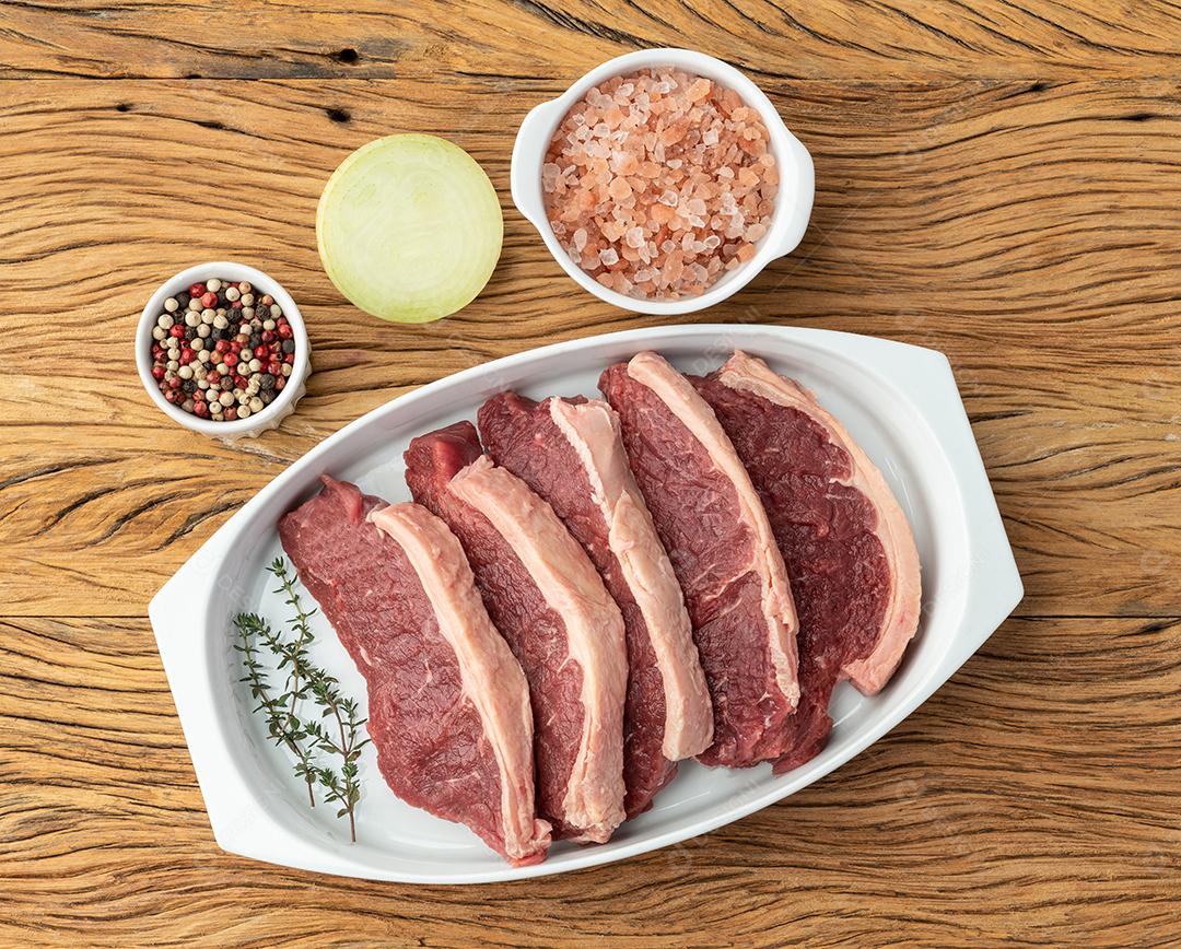 Carne de lombo de tira crua fatiada sobre prato branco com temperos