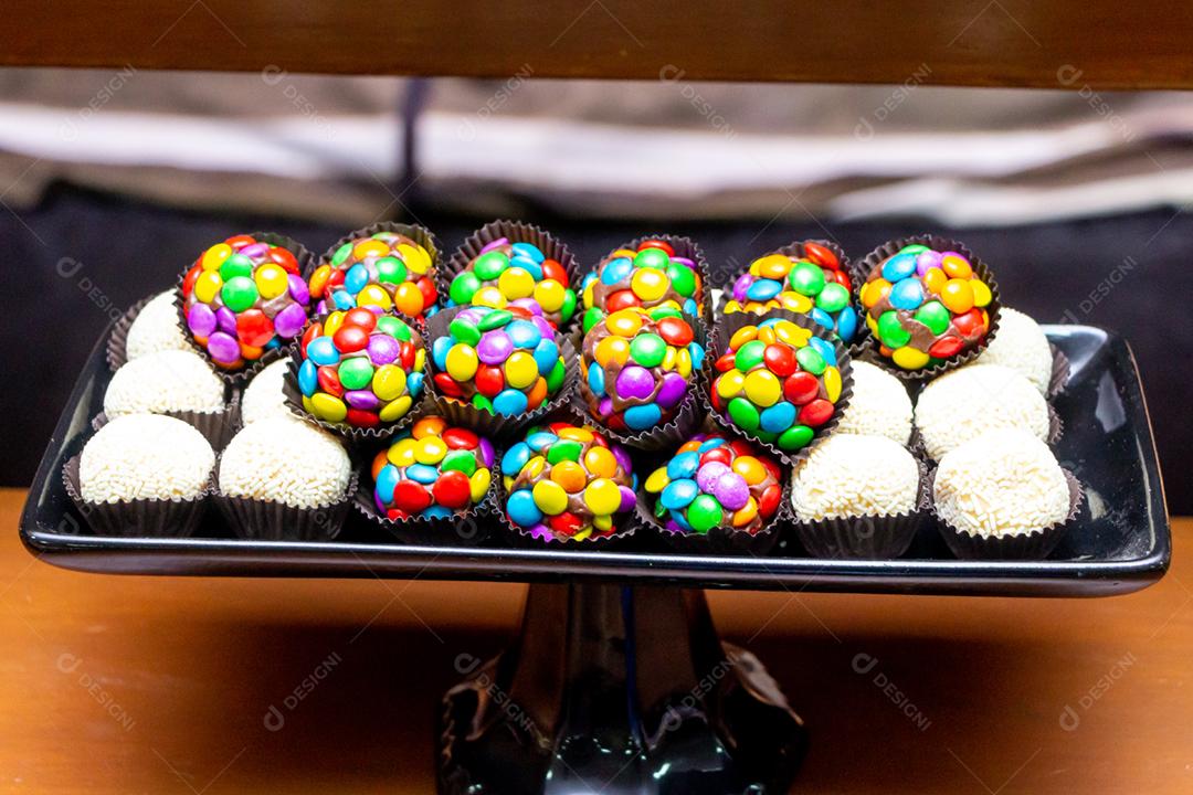Doces brigadeiros sobre mesa de madeira