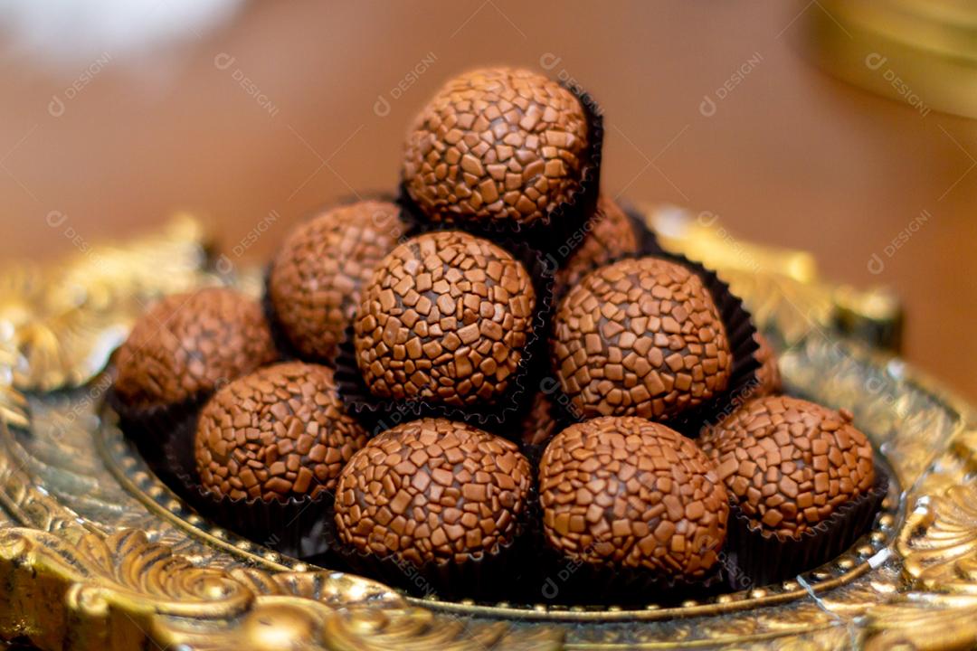 Doces brigadeiros sobre mesa de madeira