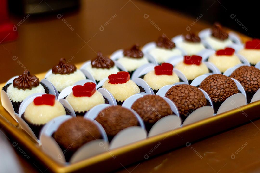 Doces brigadeiros sobre mesa de madeira