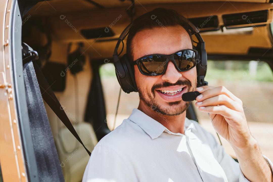 Piloto usando fones de ouvido sobre Helicóptero