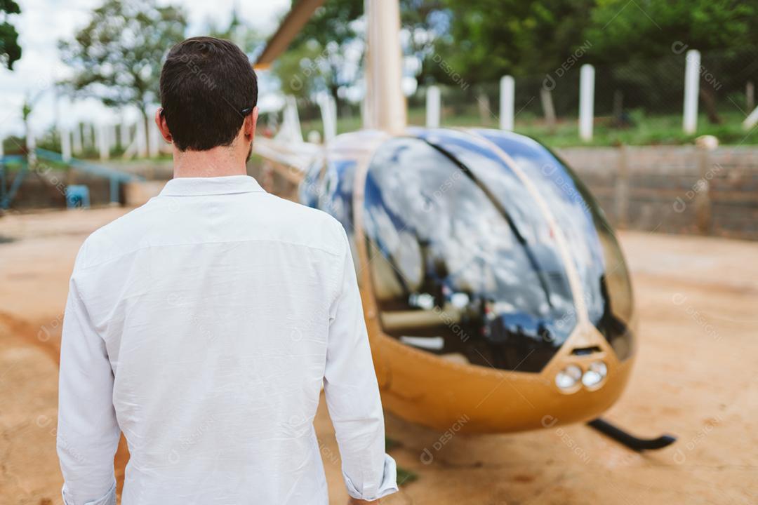 Homem bem sucedido perto de um Helicóptero