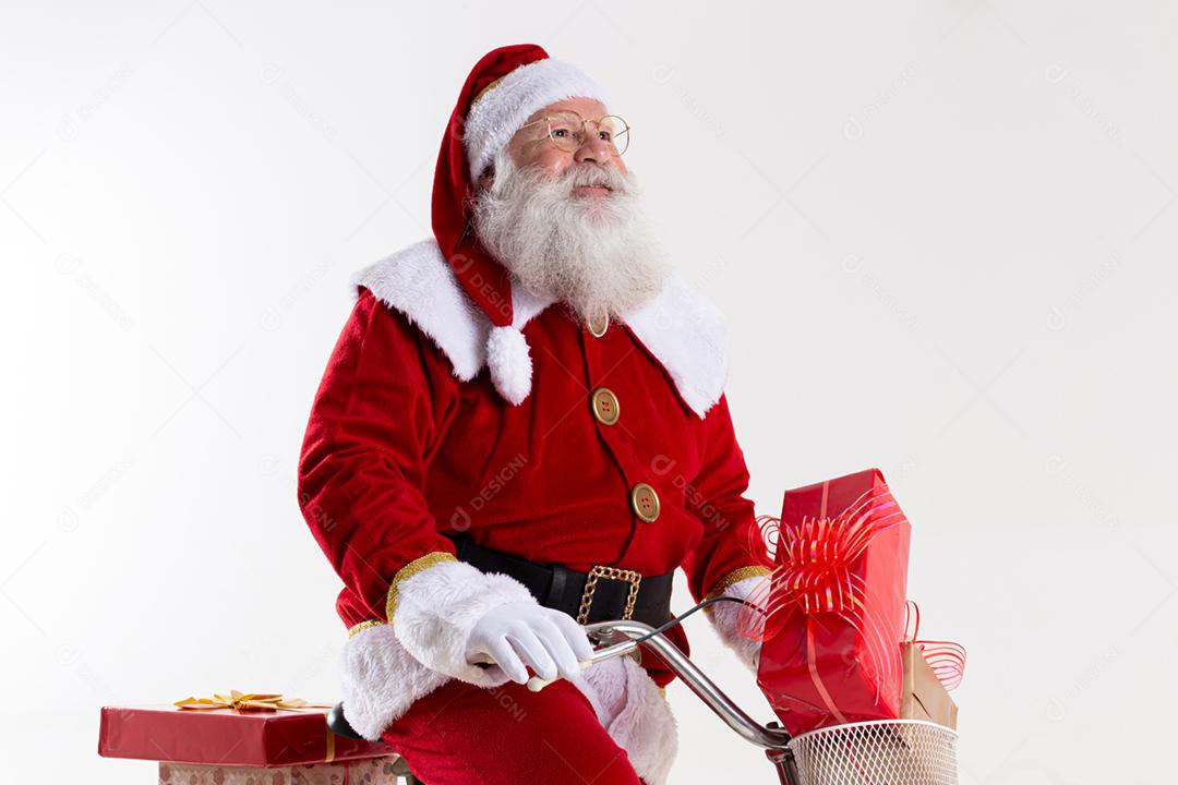 Papai Noel de bicicleta entregando presentes de Natal.