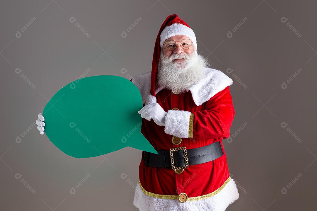 Papai Noel segurando balão de texto em branco.