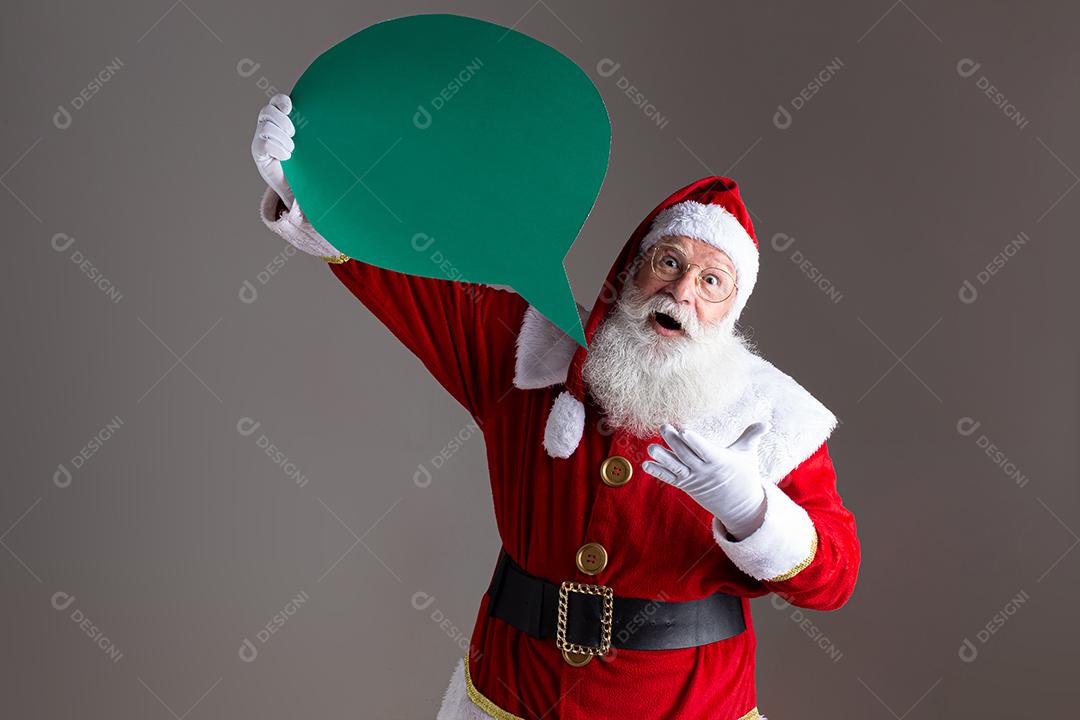 Papai Noel segurando balão de texto em branco.