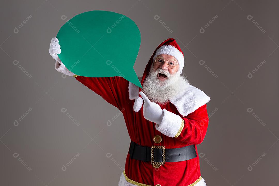 Papai Noel segurando balão de texto em branco.