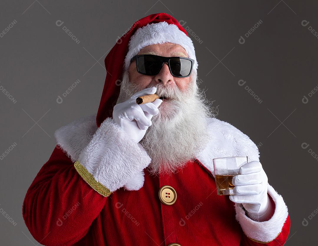 Papai Noel usando óculos escuros fumando um charuto e bebendo
