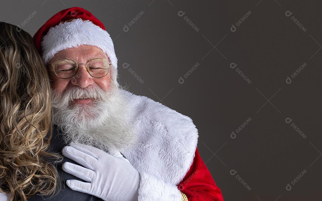 Papai Noel feliz abraçando mulher, gratidão e amor no Natal