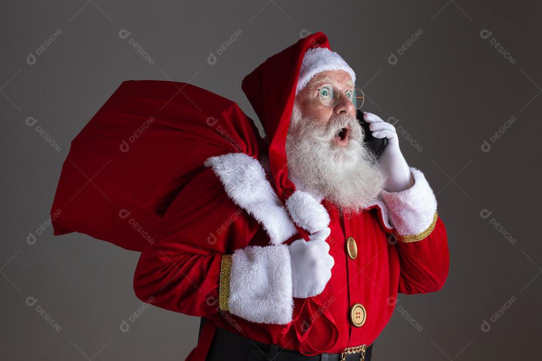 Papai Noel usando um smartphone. Surpreso.