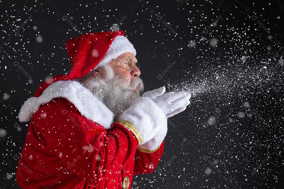 Tradições natalinas. Papai Noel soprando flocos de neve.