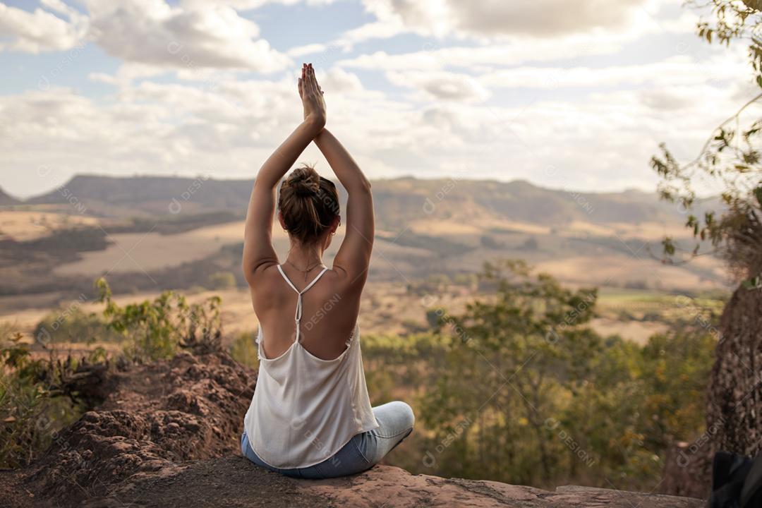 Jovem mulher latina meditando na natureza. Meditação de mulher de ioga saudável ao pôr do sol.