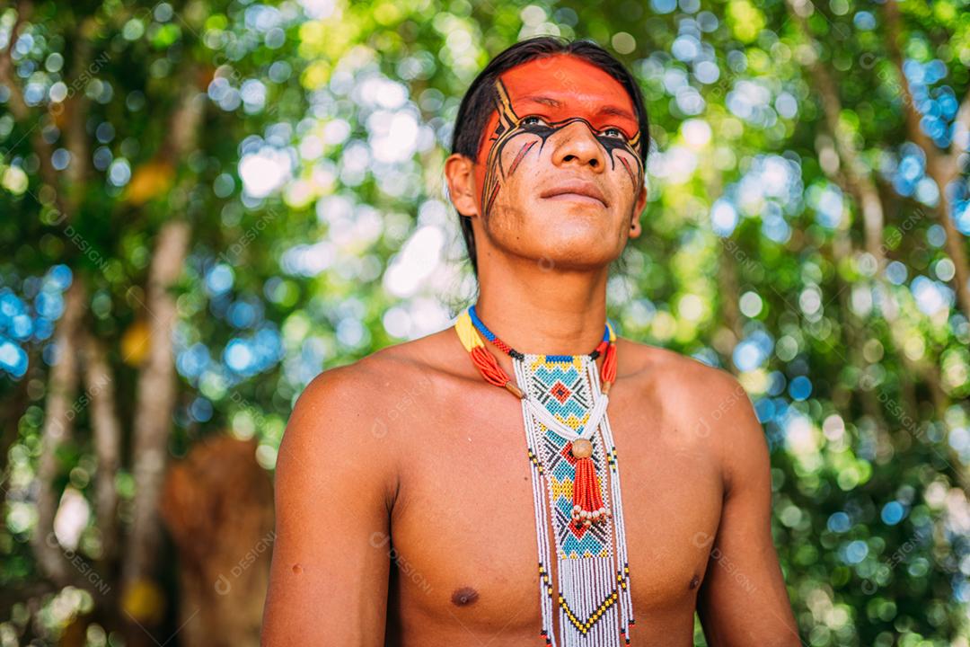 Índio da tribo Pataxó sorrindo. Índio brasileiro do sul da Bahia com colar e pinturas faciais tradicionais olhando para a direita