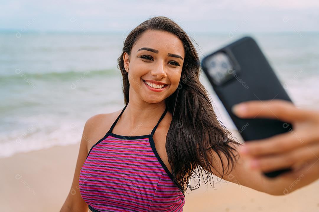 Linda mulher latina-americana fazendo selfie fundo de praia
