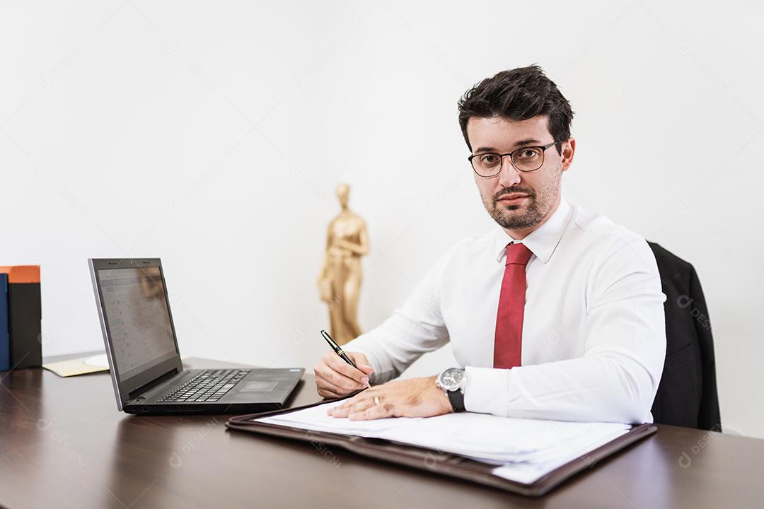 Empresário trabalhando no escritório com laptop e documentos