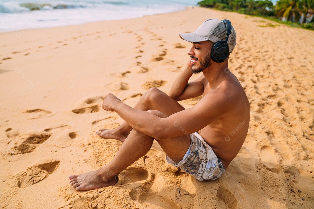 Feche o retrato de um homem latino-americano sentado na areia