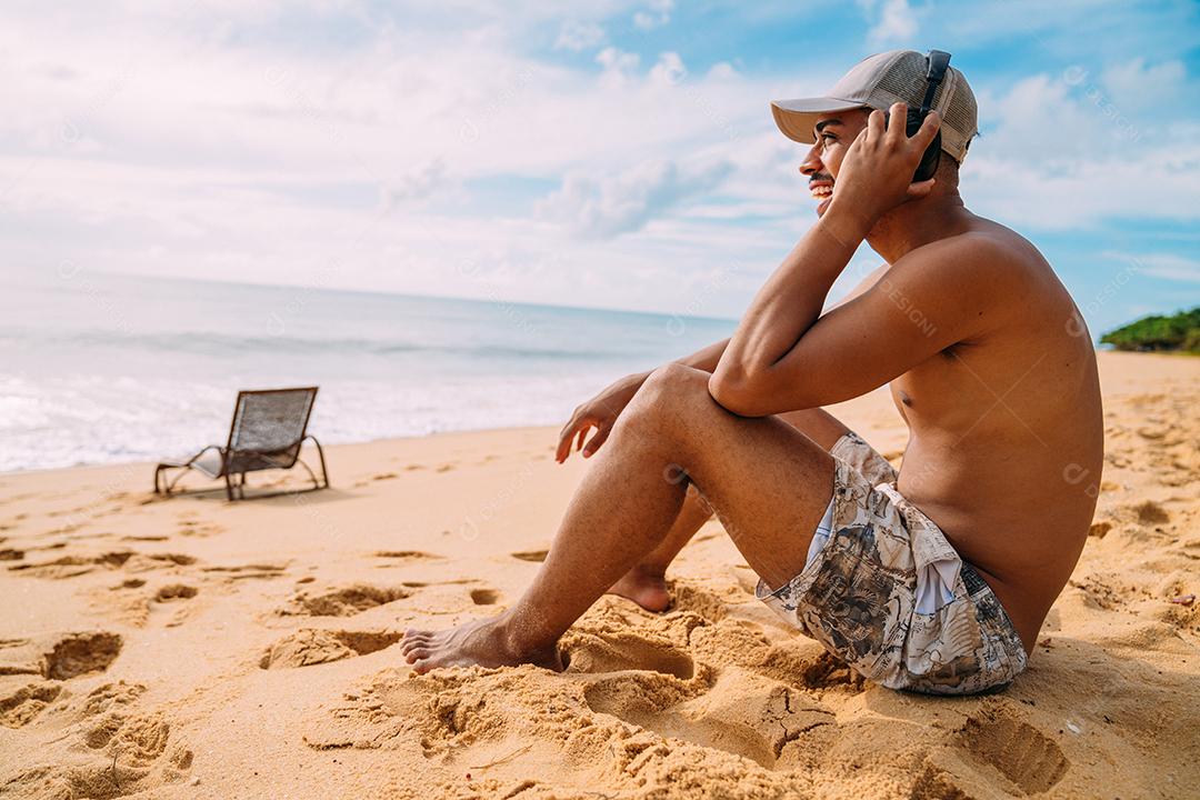 Feche o retrato de um homem latino-americano sentado na areia