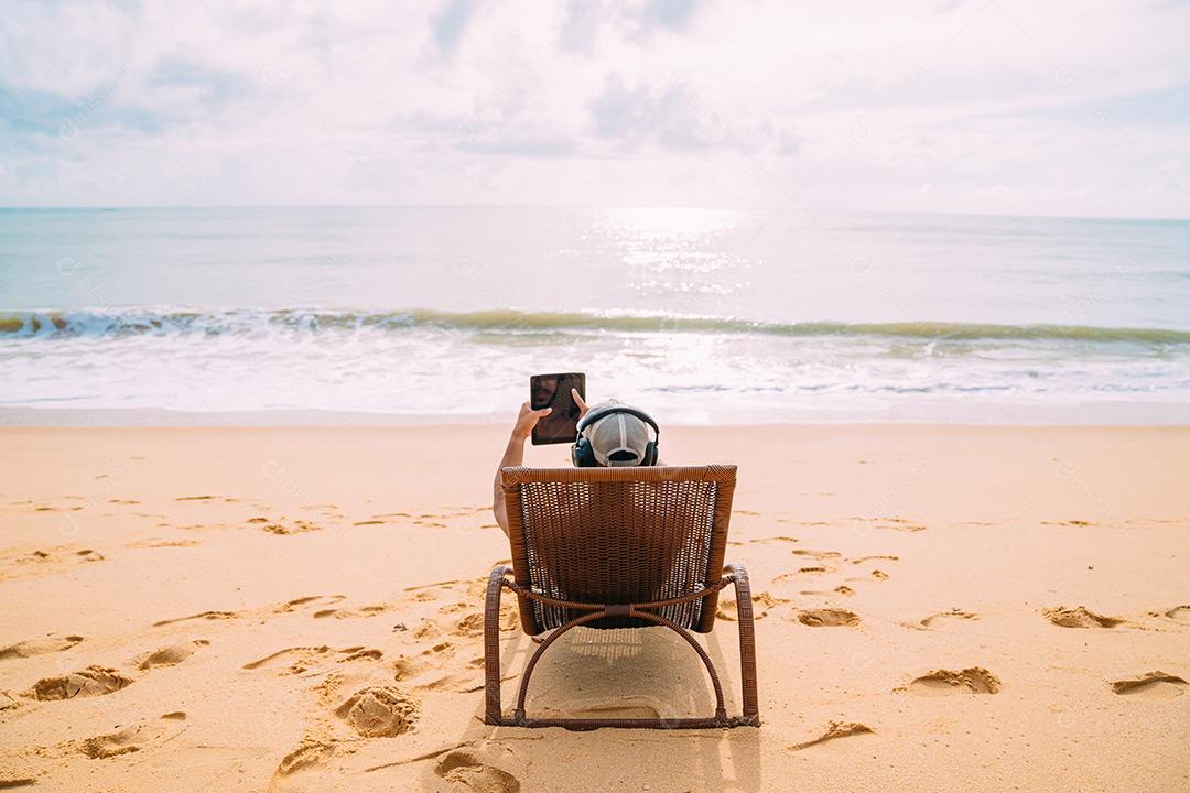 Homem fazendo uma chamada de vídeo nas férias de verão. homem latino-americano