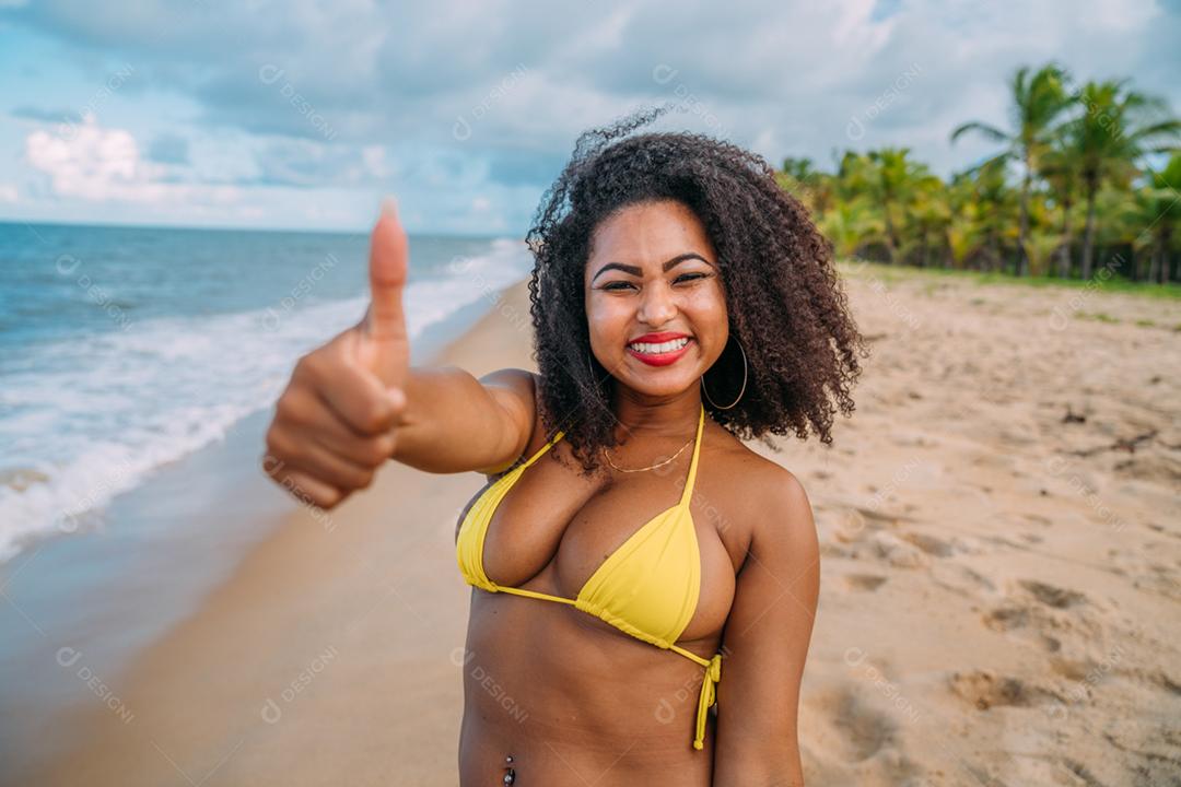 Linda mulher latino-americana de biquíni na praia. Jovem curtindo suas férias de verão em um dia ensolarado