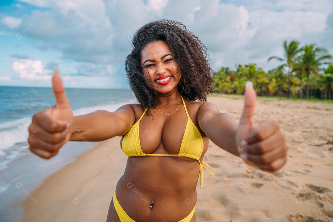 Linda mulher latino-americana de biquíni na praia. Jovem curtindo suas férias de verão em um dia ensolarado