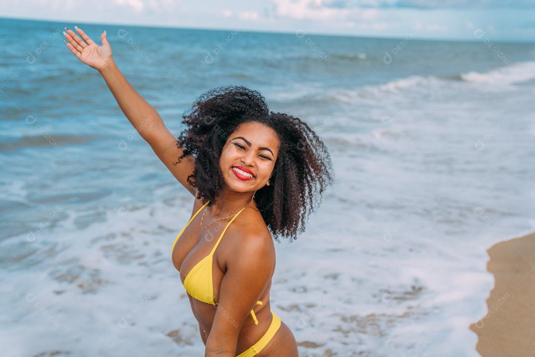 Linda mulher latino-americana de biquíni na praia. Jovem curtindo suas férias de verão em um dia ensolarado