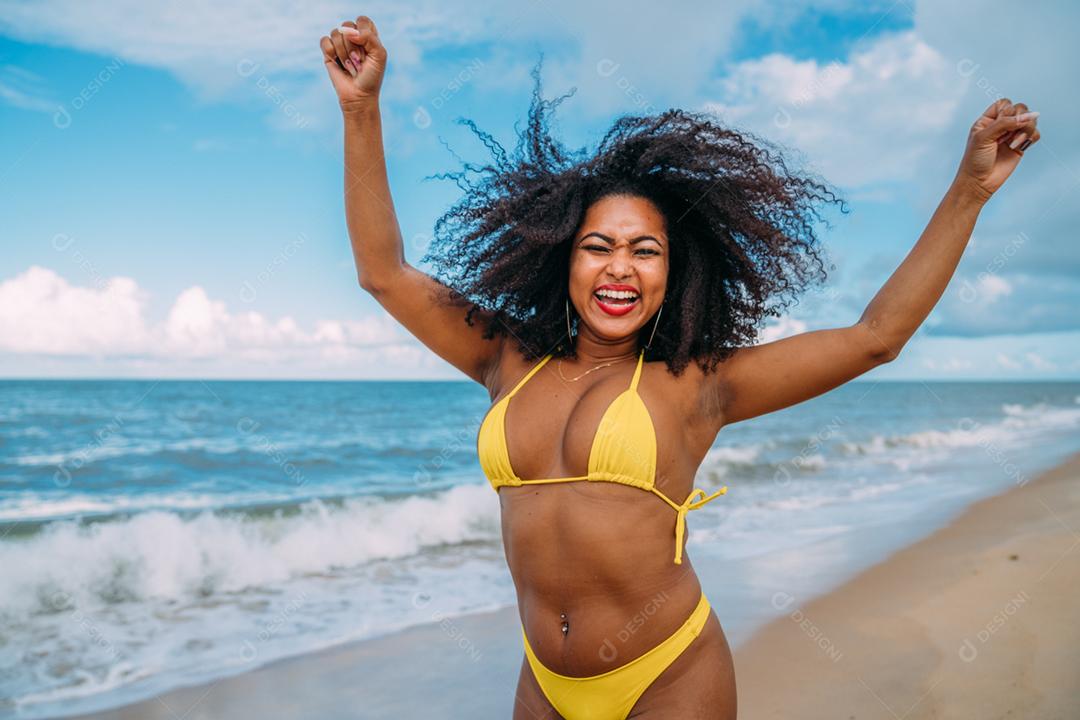 Linda mulher latino-americana de biquíni na praia. Jovem curtindo suas férias de verão em um dia ensolarado