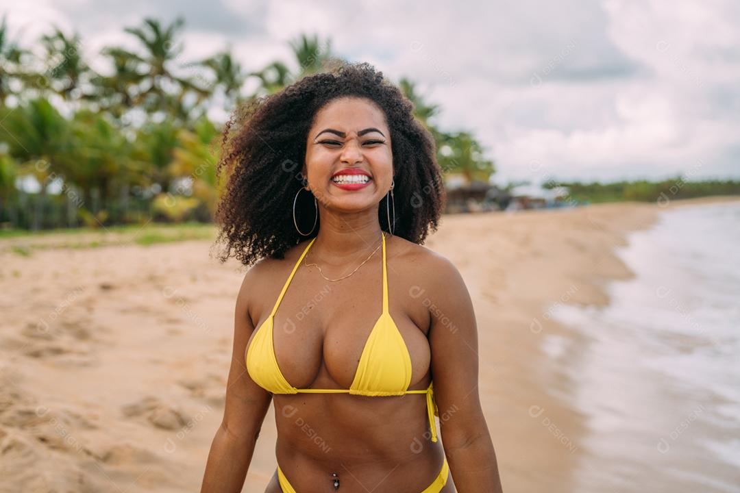 Linda mulher latino-americana de biquíni na praia. Jovem curtindo suas férias de verão em um dia ensolarado