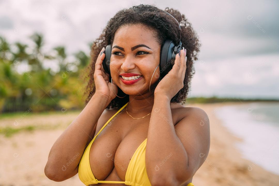 Férias de verão, tecnologia e conceito de internet. mulher latino-americana ouvindo música com fone de ouvido