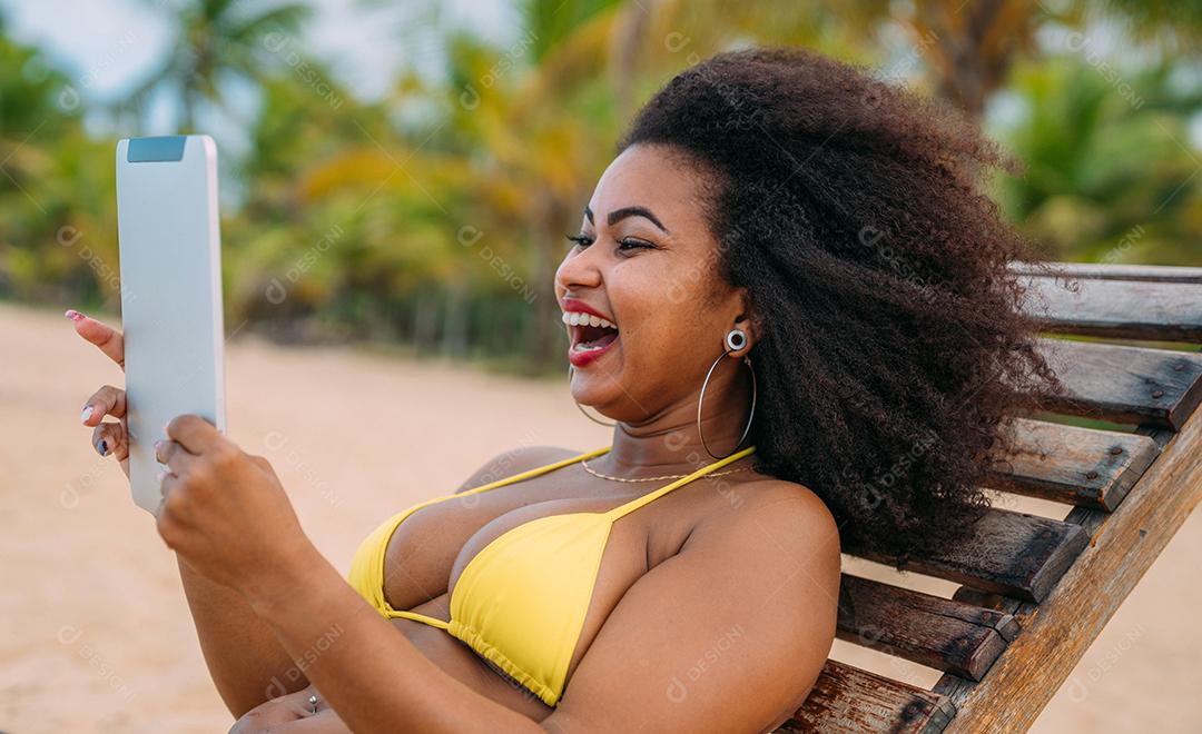 Mulher fazendo uma chamada de vídeo nas férias de verão. mulher latina-americana