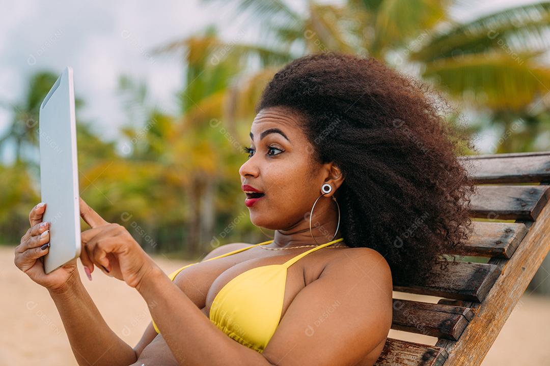 Mulher fazendo uma chamada de vídeo nas férias de verão. mulher latina-americana