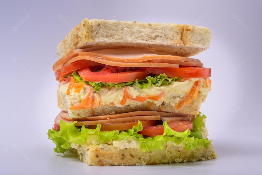 Sanduíche grande com presunto defumado, creme, alface e tomate isolado no fundo branco. Comida rápida.