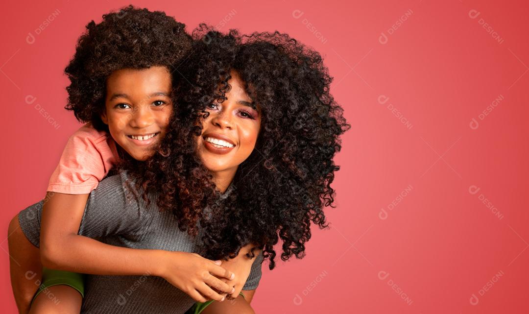 Retrato de jovem mãe afro-americana com filho da criança. Fundo vermelho. família brasileira.