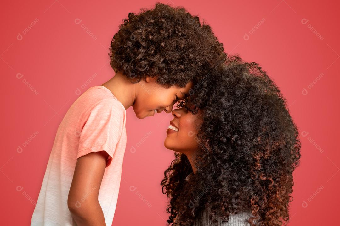 Retrato de jovem mãe afro-americana com filho da criança. Fundo vermelho. família brasileira.