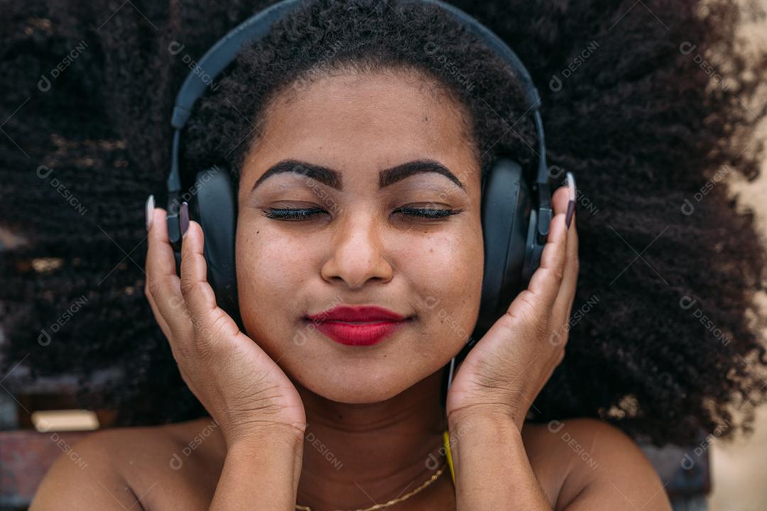 férias de verão, tecnologia e conceito de internet. mulher latino-americana ouvindo música com fone de ouvido