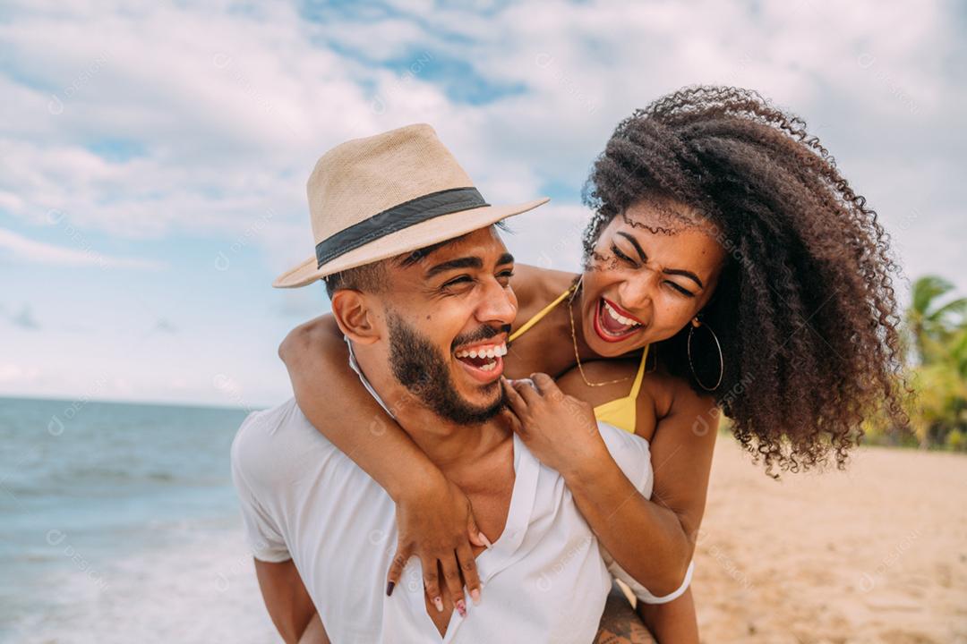 Jovem casal apaixonado na praia, férias de verão, feliz e sorrindo de mãos dadas