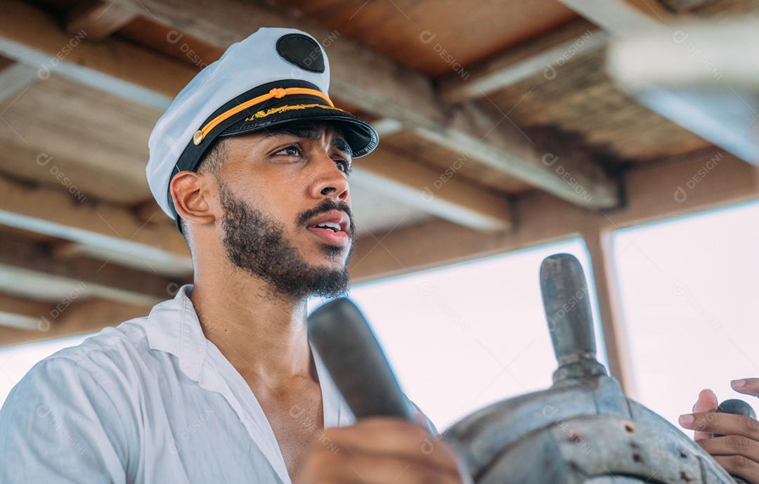 Esporte de vela. Capitão responsável. Homem latino-americano com chapéu de capitão de navio.