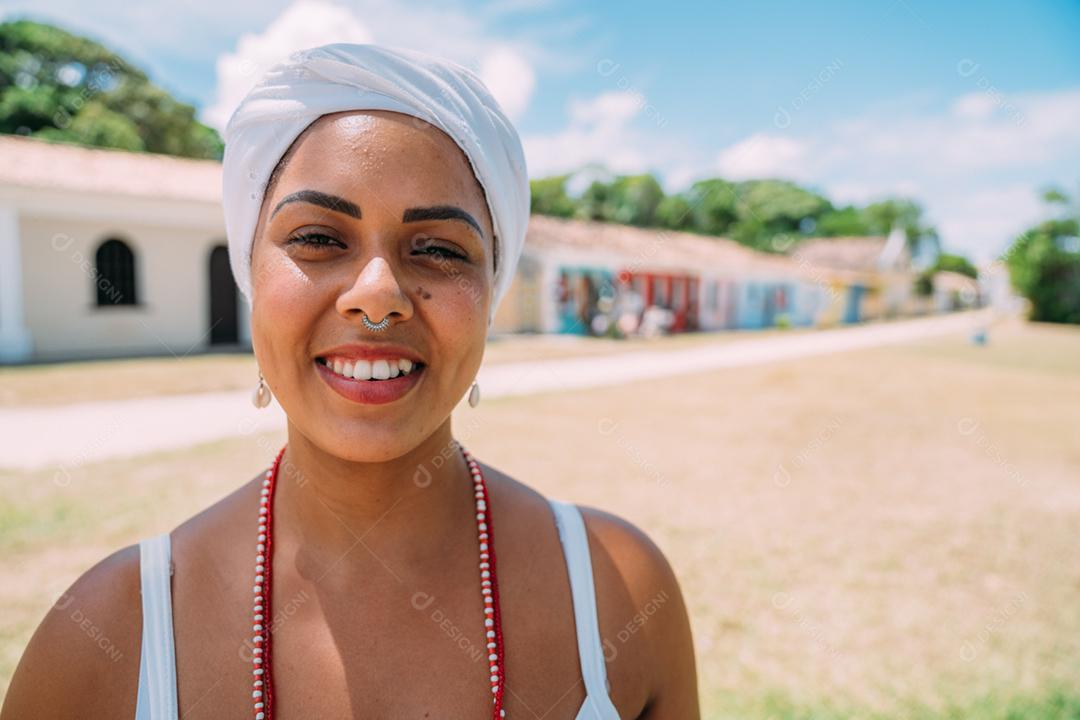 Feliz mulher brasileira vestida com traje tradicional baiano dançando no centro histórico de Porto Seguro