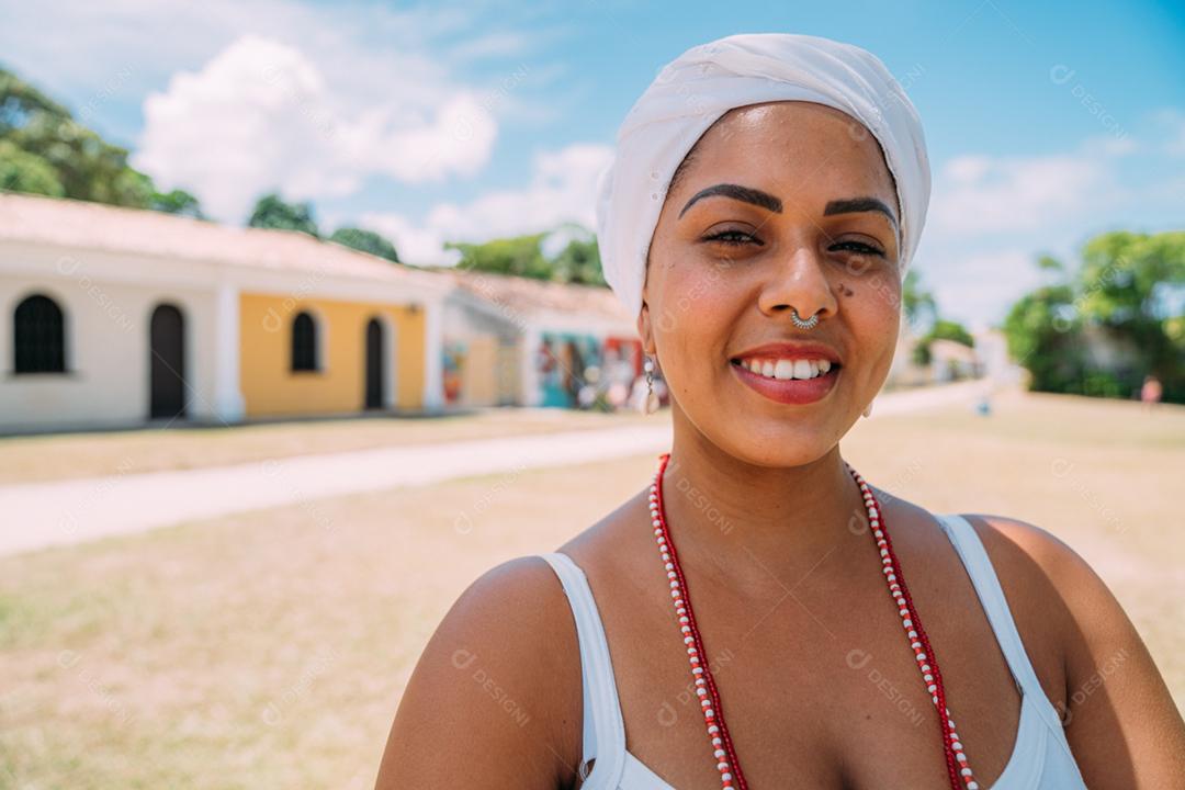 Feliz mulher brasileira vestida com traje tradicional baiano dançando no centro histórico de Porto Seguro