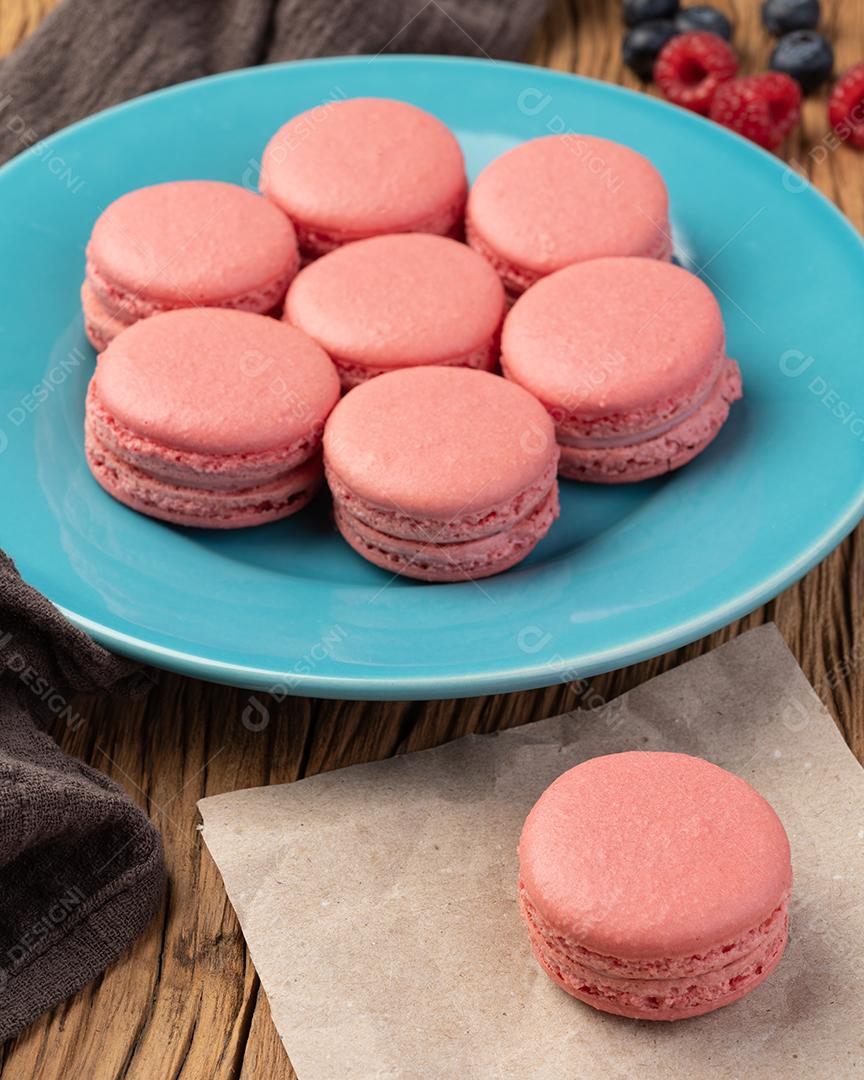 Macarons de frutas em um prato sobre mesa de madeira