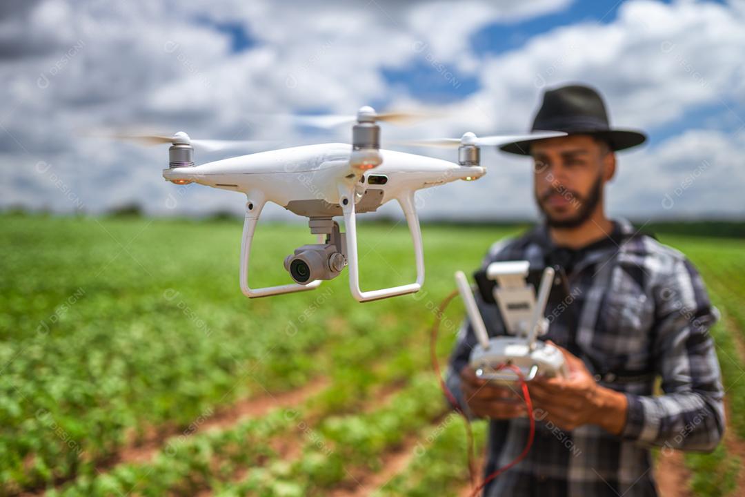 Conceito de agricultura inteligente, agricultor latino-americano usando drone em campo