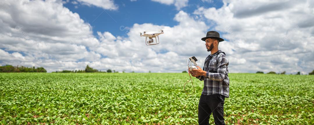 Conceito de agricultura inteligente, agricultor latino-americano usando drone em campo
