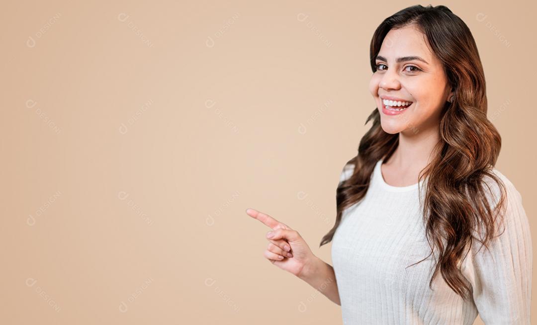 Linda mulher latina vestindo roupas casuais sorrindo feliz apontando com a mão e o dedo para o lado